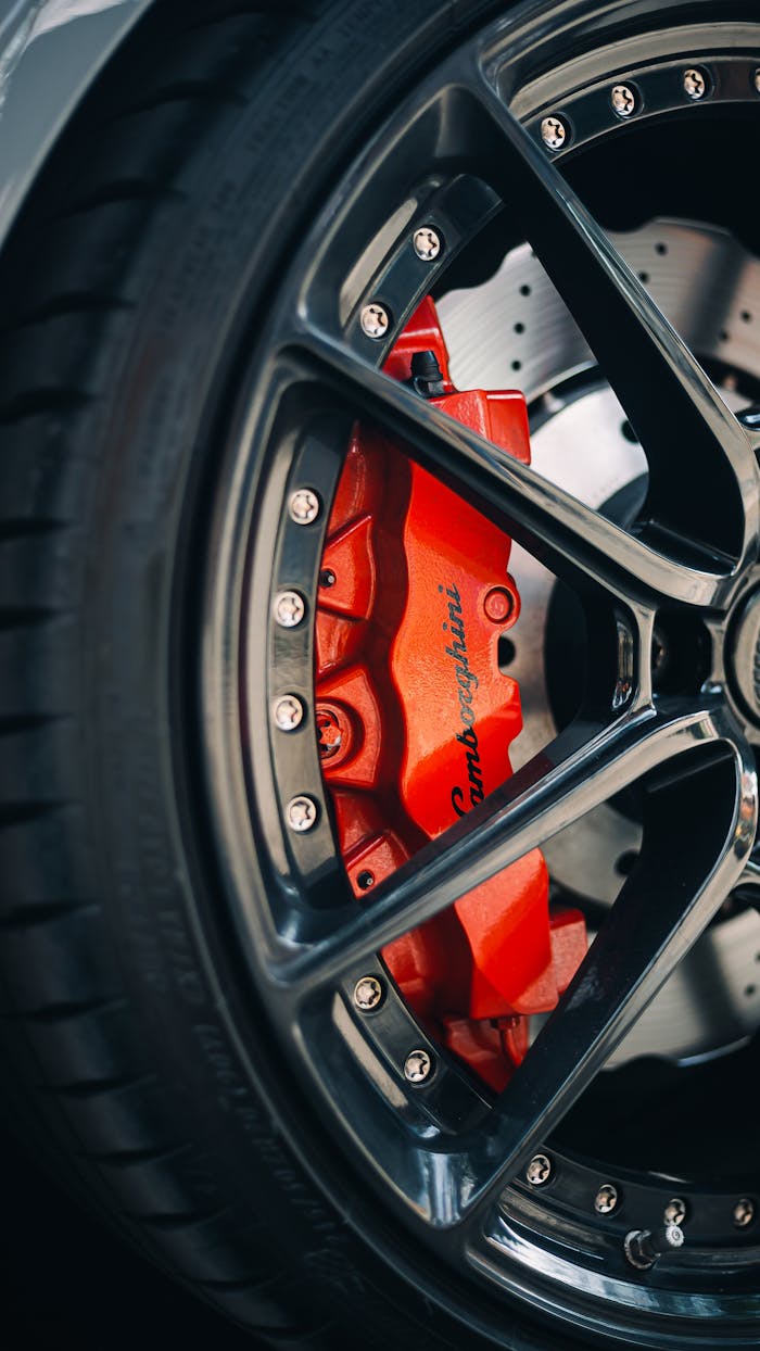 gallery-1 Detailed shot of a Lamborghini brake disc with red brake caliper, showcasing luxury and precision.