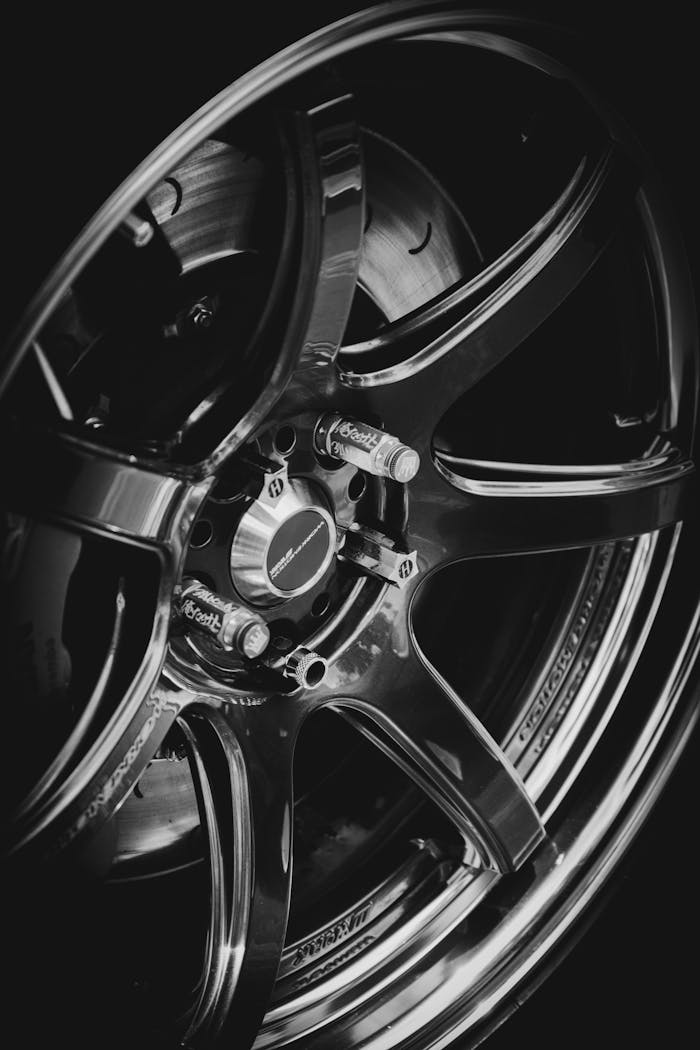 gallery-5 Detailed close-up of a stylish car wheel showcasing its intricate design and metallic finish.