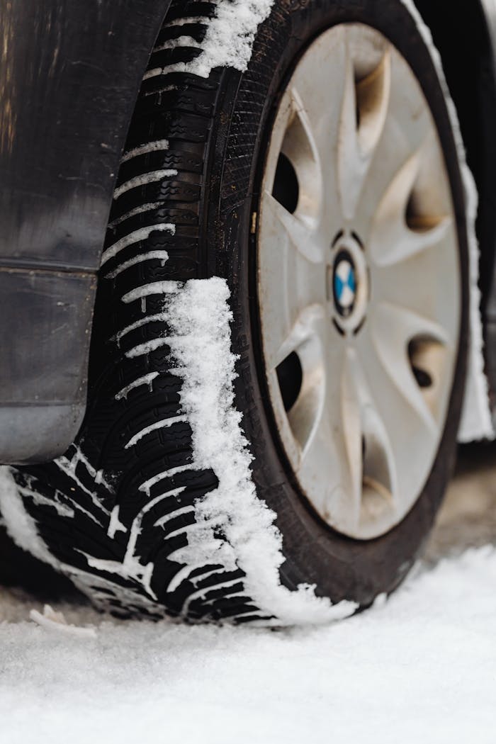 gallery-2 Close-up of a tire with snow, highlighting the wheel and snowy tread.