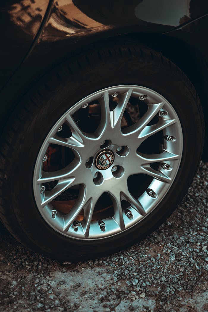 hero-img-02 Detailed shot of a shiny alloy wheel on a vehicle, showcasing intricate design and metallic texture.